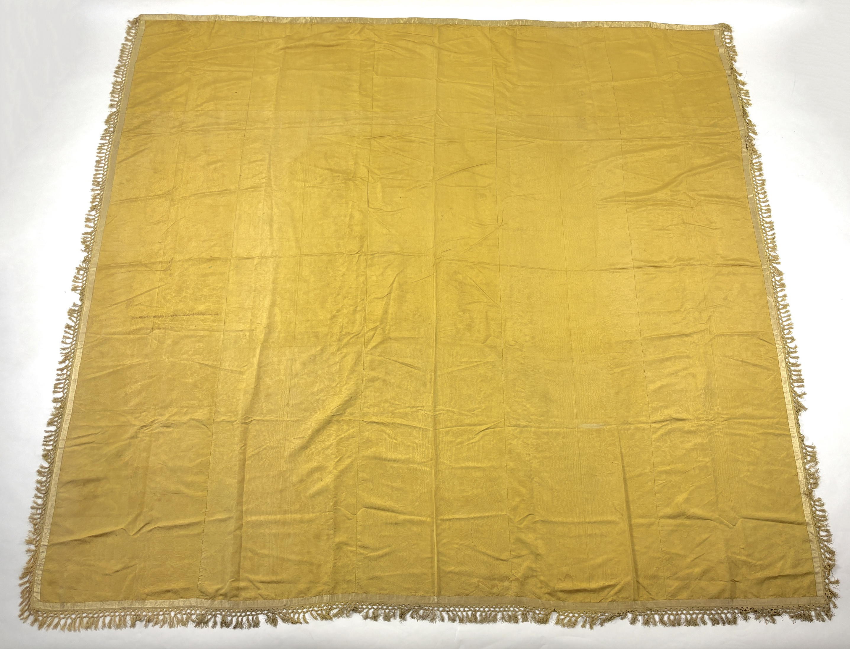 A large Regency yellow silk curtain, with fringed base, French short loom ribbed silk panels made into a wide curtain, with fringing on each side and at the bottom, 9ft wide x 8ft 6in. long